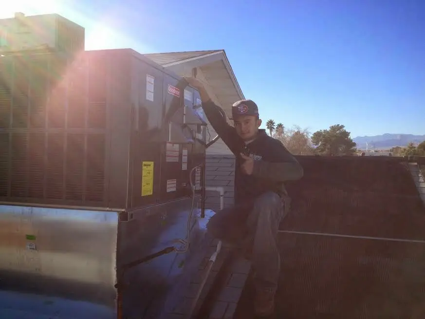 HVAC technician performing HVAC Inspection on a rooftop unit in Grantsville